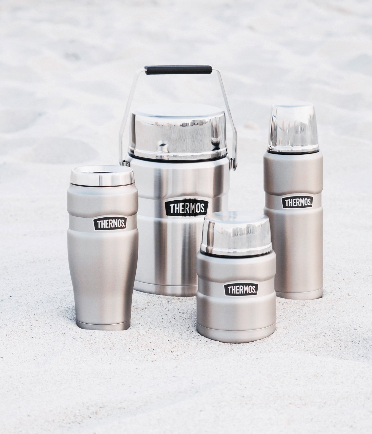 Verschiedene Thermosprodukte im Sand in Edelstahlfarbe