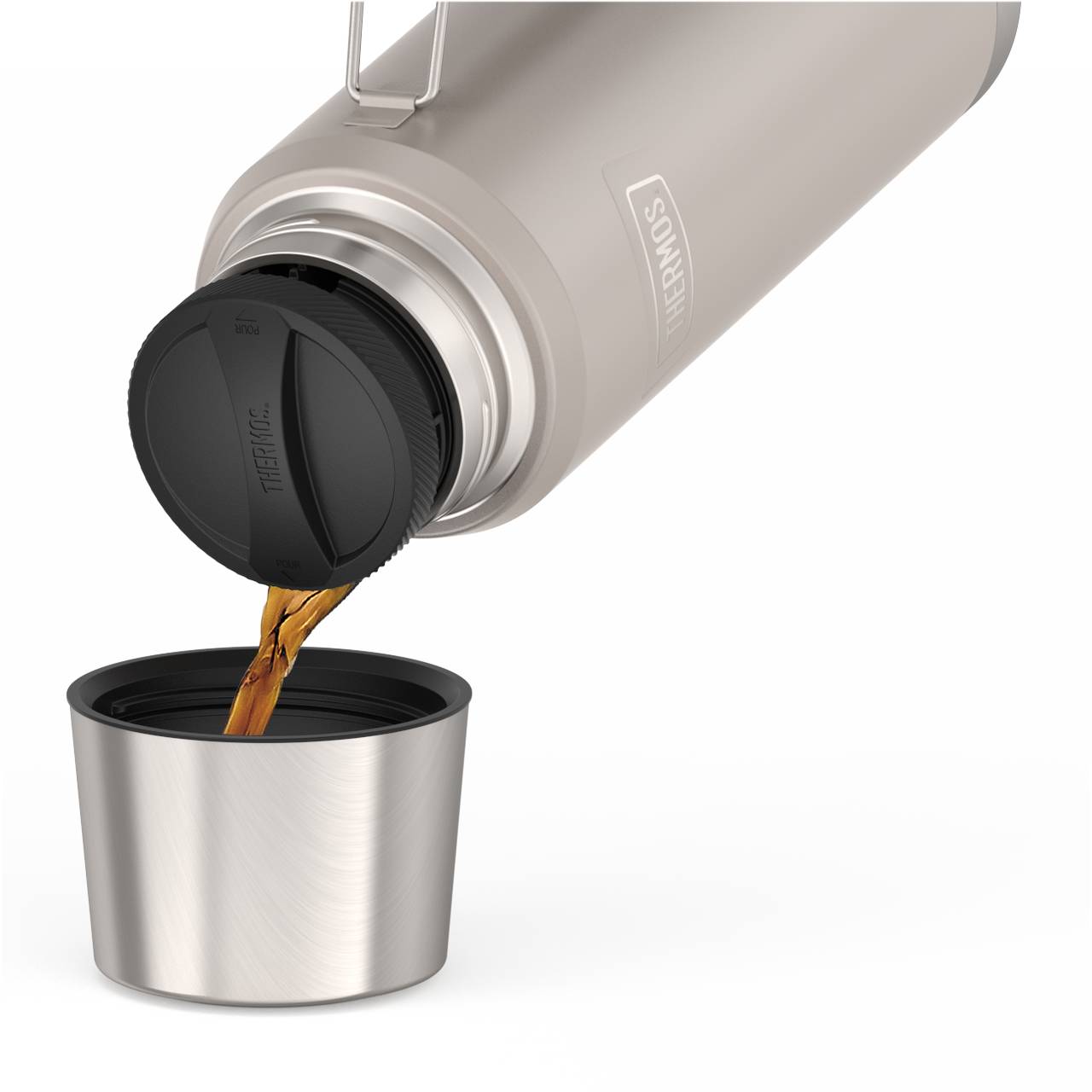 Eine silberne Thermoskanne wird auf den Kopf gestellt und gießt eine Flüssigkeit, wahrscheinlich Kaffee oder Tee, in eine dazugehörige silberne Tasse. Der Hintergrund ist schlicht und weiß, und der Fokus liegt auf dem Fließvorgang der Flüssigkeit.